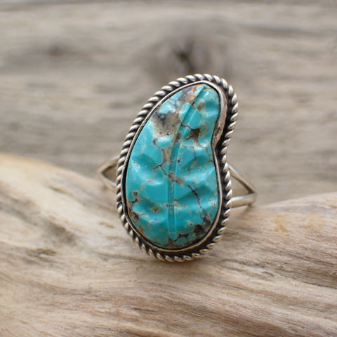 turquoise carved leaf ring on driftwood
