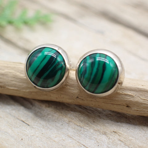 round green malachite stone earrings on a piece of driftwood