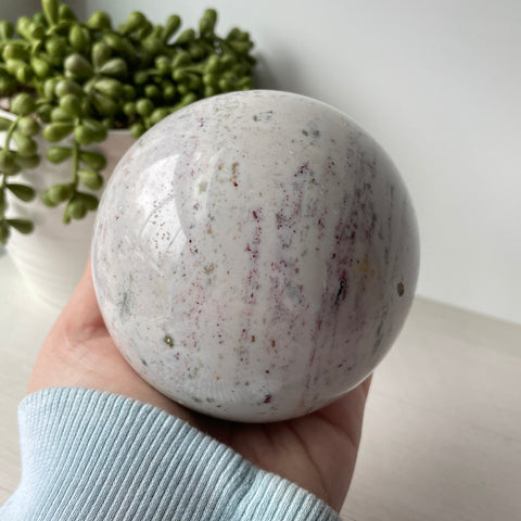 Esfera de jaspe oceánico rosa, blanco y verde sobre soporte de metal