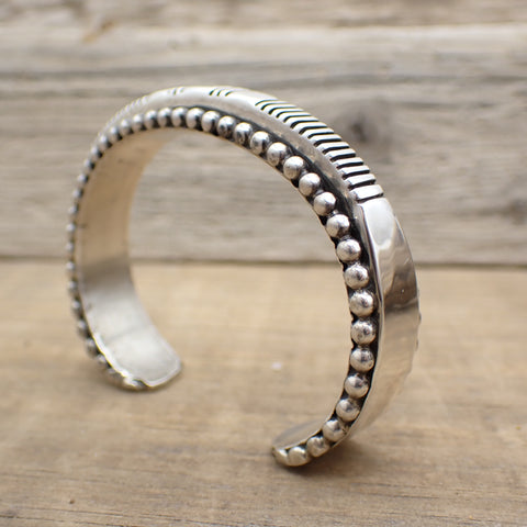 sterling silver hand made cuff bracelet with lines and dots on driftwood.